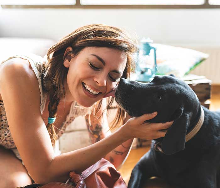 Pet sitter smiling with a black dog in Richmond, TX