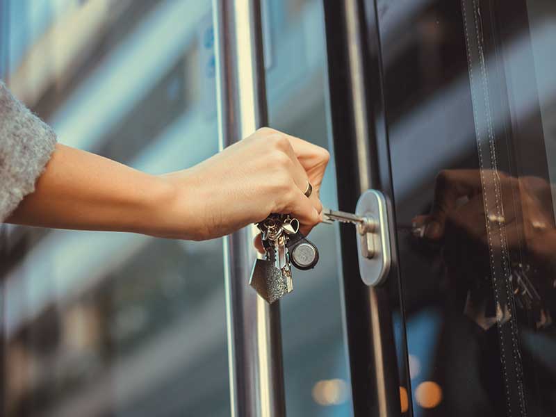 Pet sitter locking the front door to a home after leaving during home sitting services